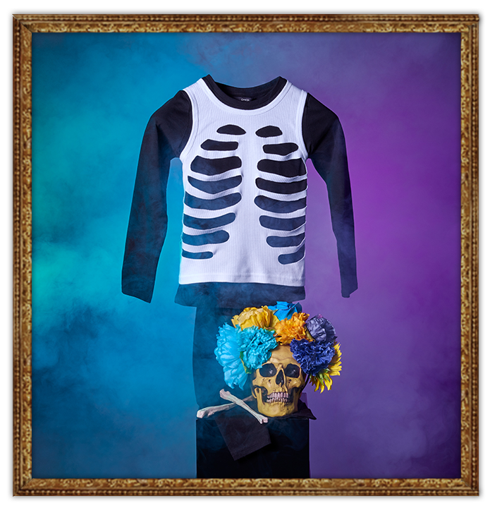 DIY George skeleton Halloween costume and yellow skull covered in flowers, all shrouded in smoke